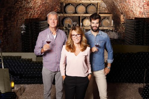 three family business owners in a winery barrel room